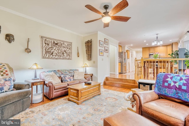 living room with ornamental molding, light hardwood / wood-style floors, and ceiling fan