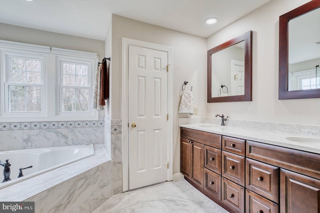 bathroom featuring vanity and tiled tub