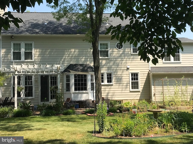 rear view of property with a pergola and a yard