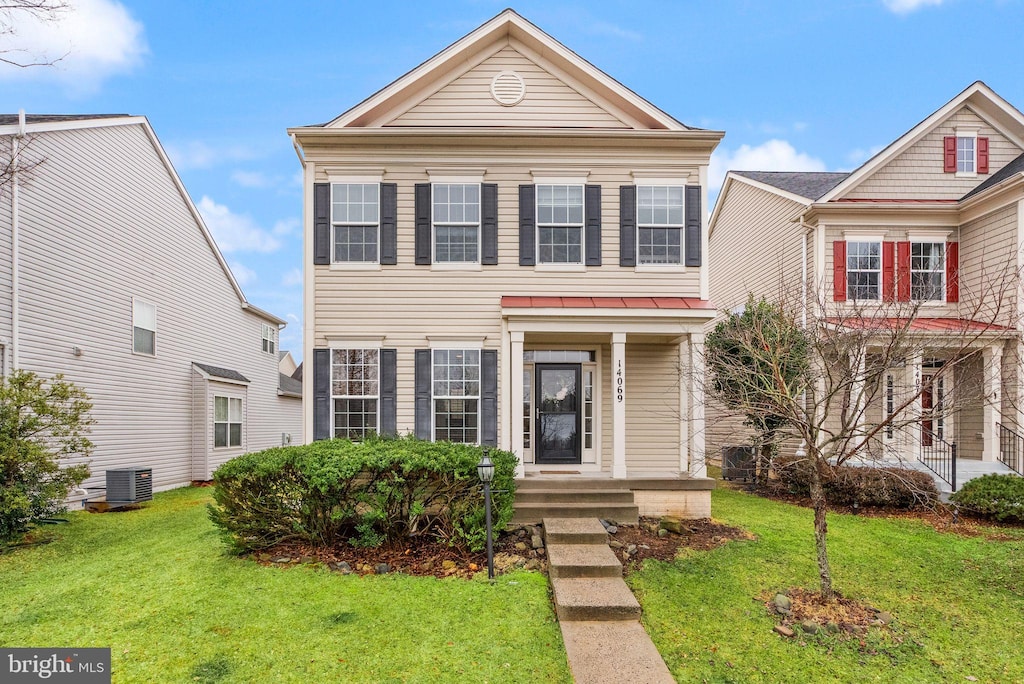 view of front of house featuring central AC and a front lawn