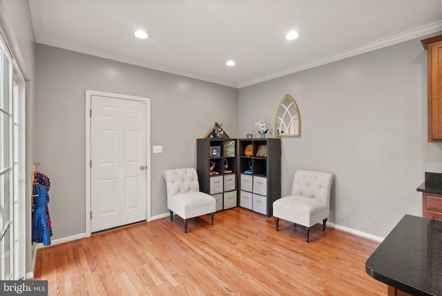 living area featuring ornamental molding and light hardwood / wood-style floors