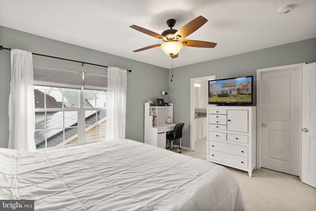 carpeted bedroom with connected bathroom and ceiling fan