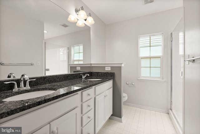 bathroom featuring vanity, tile patterned flooring, toilet, and walk in shower