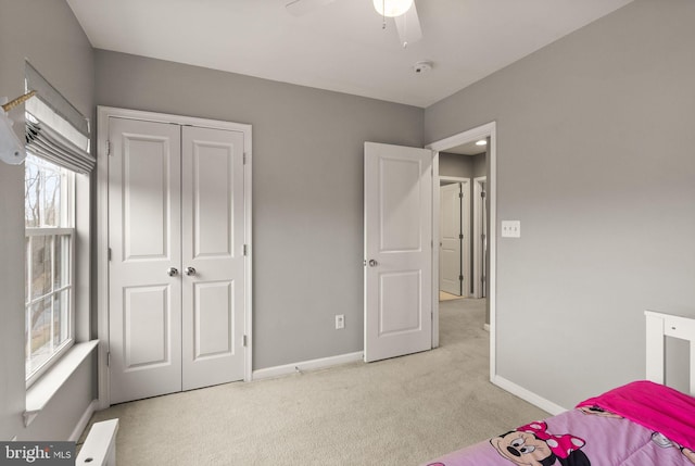 carpeted bedroom with ceiling fan and a closet