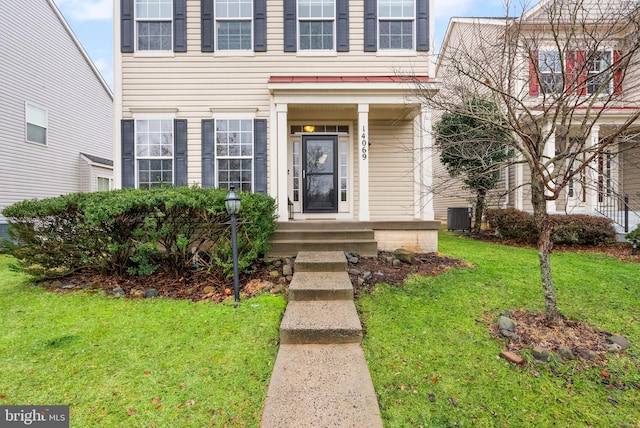 property entrance with a lawn and central air condition unit