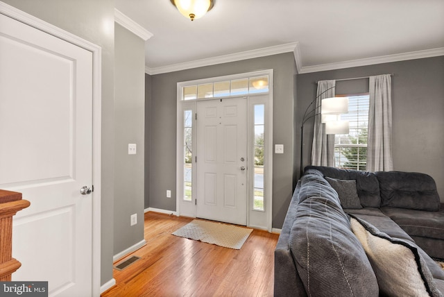 entrance foyer with crown molding and light hardwood / wood-style flooring