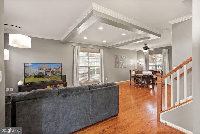 living room featuring hardwood / wood-style flooring, a healthy amount of sunlight, and crown molding