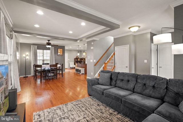 living room featuring crown molding, hardwood / wood-style floors, a tray ceiling, and ceiling fan