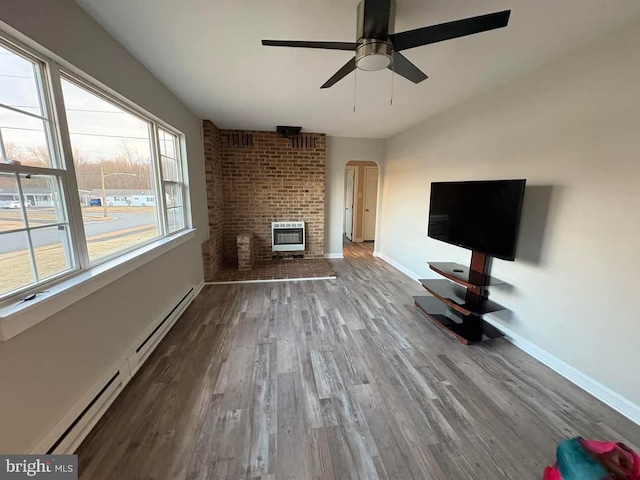 unfurnished living room featuring ceiling fan, a baseboard radiator, wood-type flooring, and heating unit