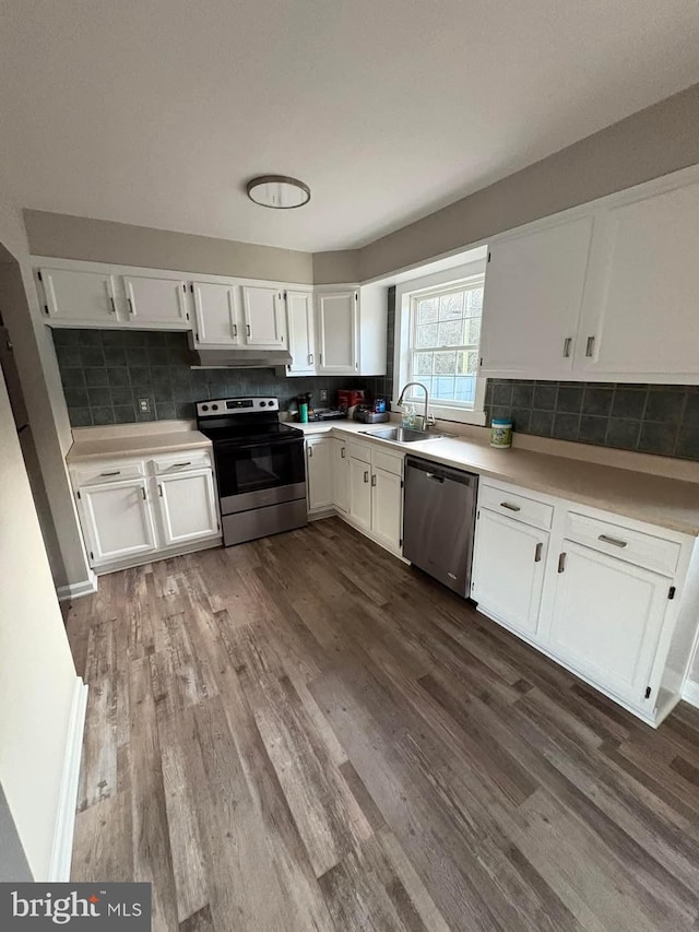 kitchen featuring hardwood / wood-style flooring, white cabinetry, appliances with stainless steel finishes, and sink