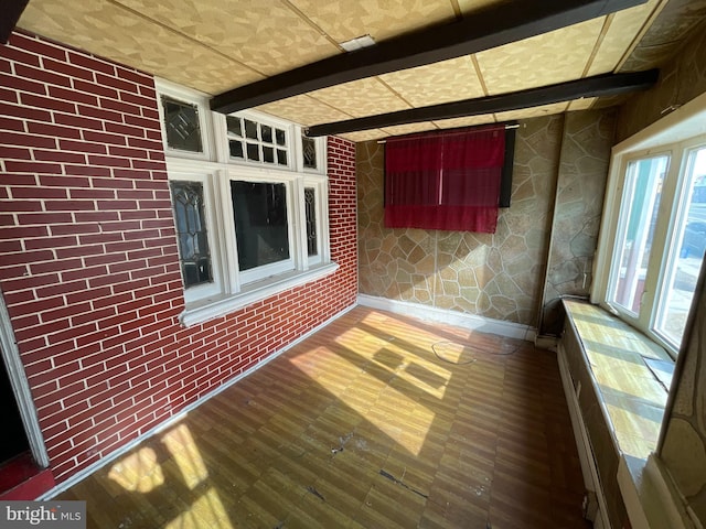 unfurnished sunroom with beam ceiling