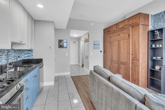 kitchen featuring white cabinetry, stainless steel appliances, sink, and decorative backsplash