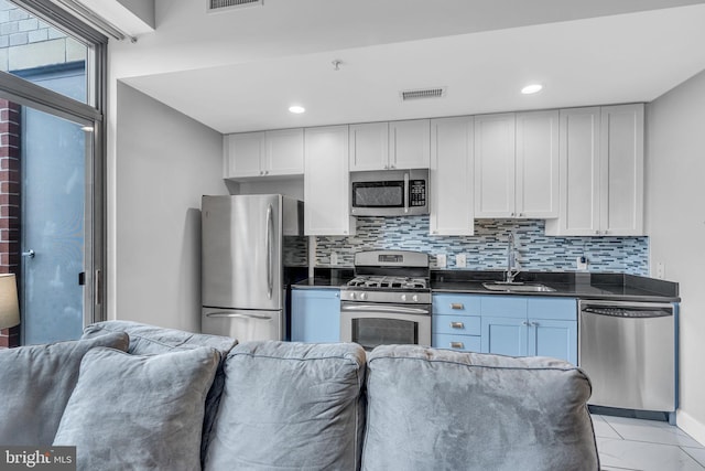 kitchen with tasteful backsplash, sink, white cabinetry, and appliances with stainless steel finishes