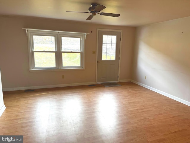 spare room featuring ceiling fan, a wealth of natural light, and light wood-type flooring