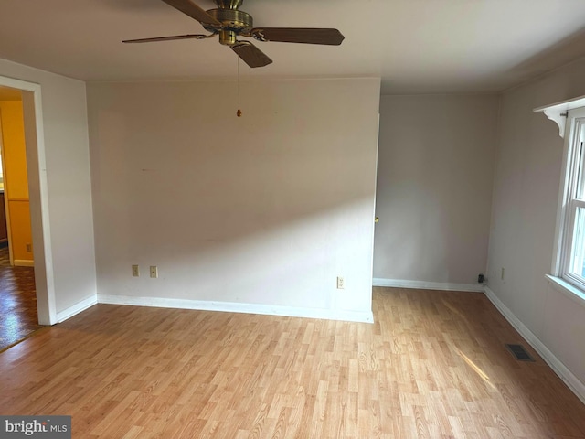 empty room with ceiling fan and light hardwood / wood-style flooring