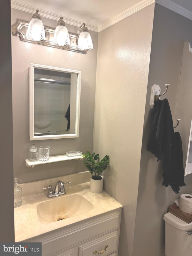 bathroom with vanity, crown molding, and toilet