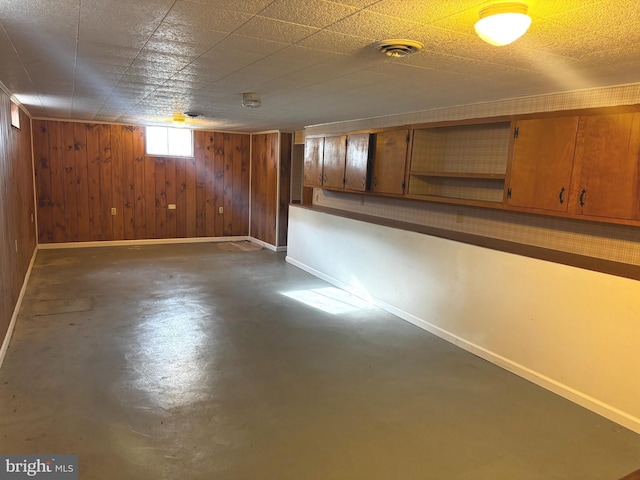 basement featuring wood walls