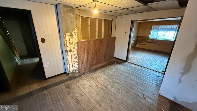 spare room featuring a paneled ceiling and wood finished floors