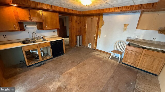 kitchen featuring brown cabinetry, black dishwasher, light countertops, and a sink