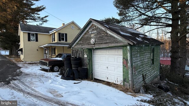 snow covered garage featuring a garage