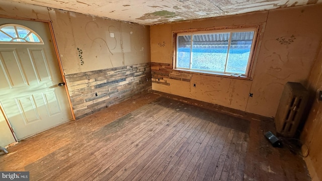 foyer with a wealth of natural light, radiator heating unit, and wood finished floors