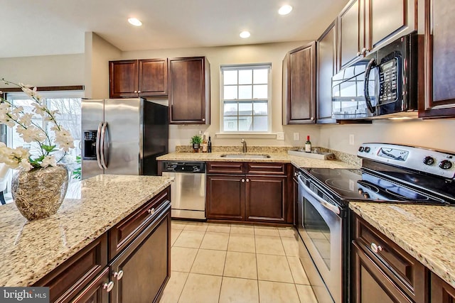 kitchen featuring light stone countertops, appliances with stainless steel finishes, sink, and light tile patterned floors