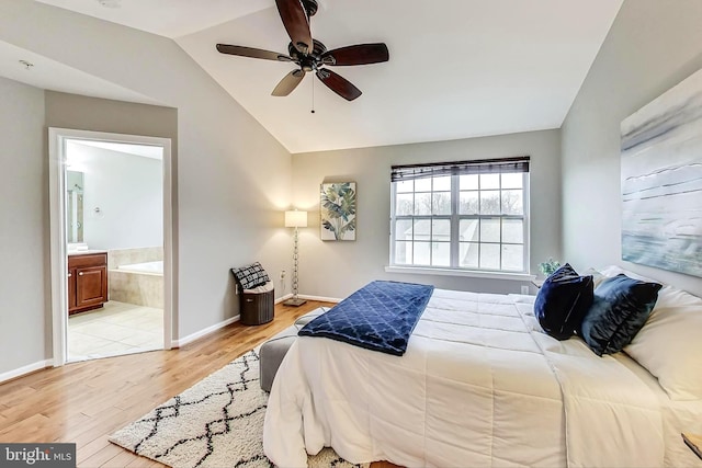 bedroom featuring lofted ceiling, ensuite bath, light hardwood / wood-style flooring, and ceiling fan