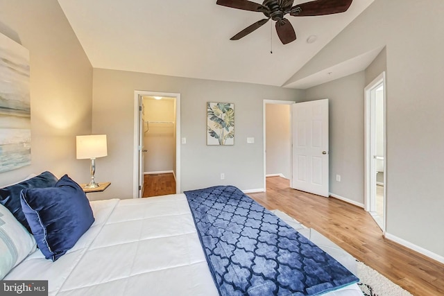 bedroom featuring ceiling fan, lofted ceiling, a spacious closet, and wood-type flooring