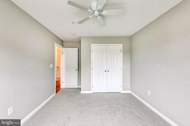 unfurnished bedroom featuring ceiling fan, light colored carpet, and a closet