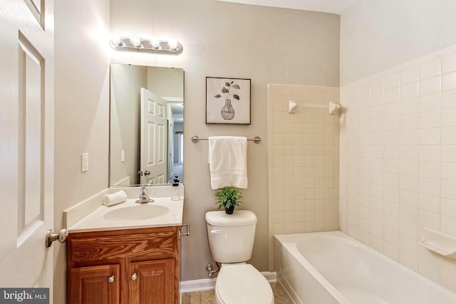 full bathroom featuring vanity, tiled shower / bath, and toilet