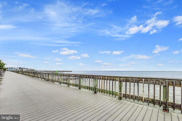 dock area with a water view and a beach view