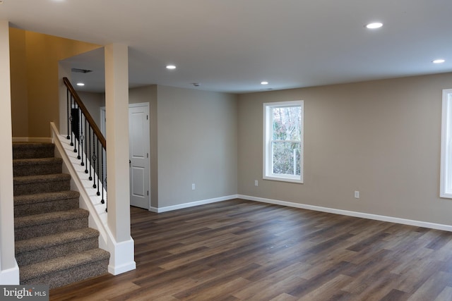 unfurnished room featuring recessed lighting, dark wood-style flooring, stairway, and baseboards