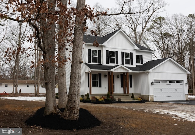 modern farmhouse with driveway, roof with shingles, and an attached garage