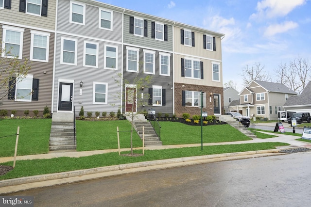 townhome / multi-family property featuring a front lawn