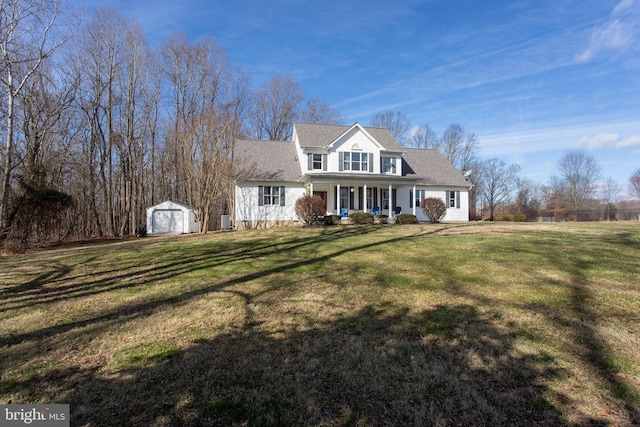 new england style home with a shed, a front yard, and covered porch