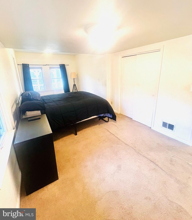 bedroom with visible vents, a closet, and carpet floors