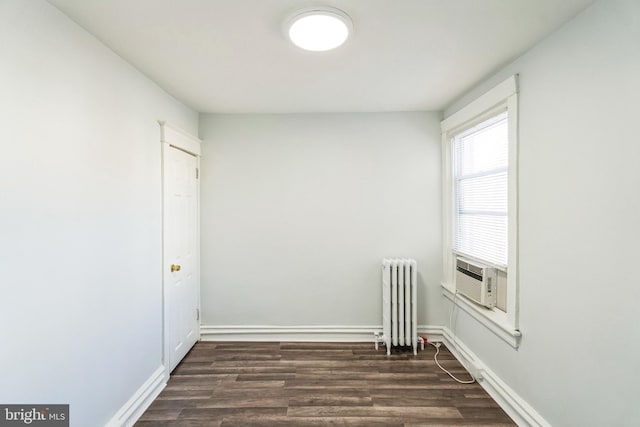 empty room with radiator, cooling unit, and dark hardwood / wood-style flooring