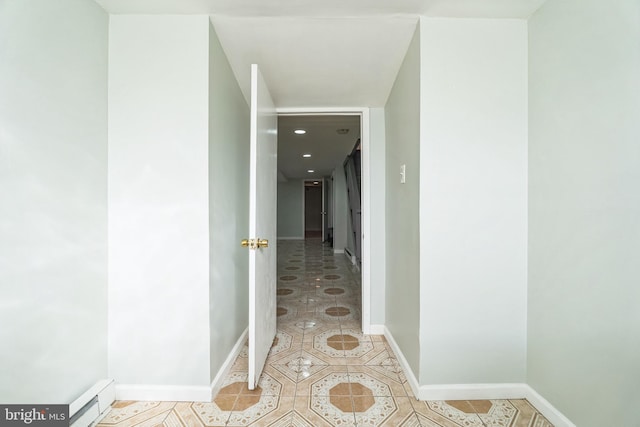 corridor with a baseboard heating unit and light tile patterned floors