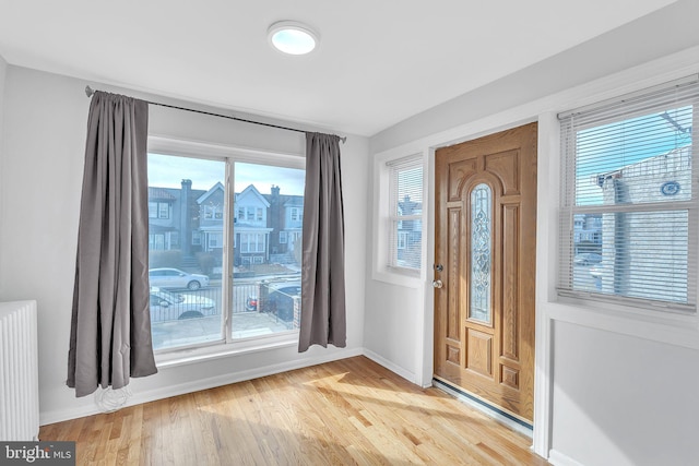 entrance foyer featuring radiator and hardwood / wood-style floors