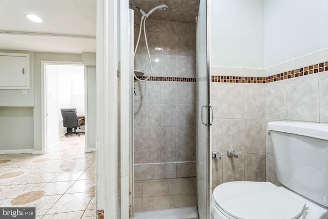 bathroom featuring walk in shower, tile patterned floors, toilet, and tile walls