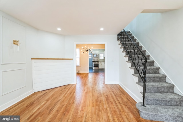 interior space featuring wood-type flooring and a notable chandelier