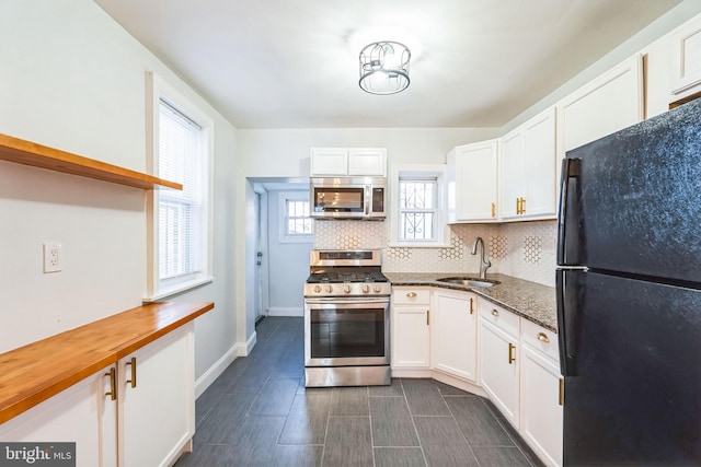 kitchen featuring sink, wooden counters, appliances with stainless steel finishes, white cabinets, and backsplash