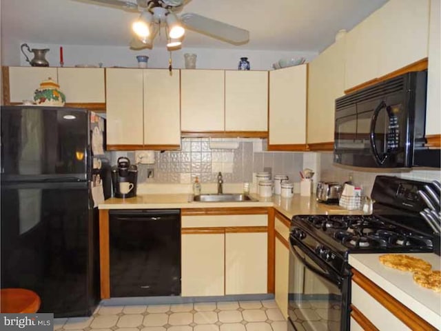 kitchen with sink, ceiling fan, cream cabinets, black appliances, and decorative backsplash