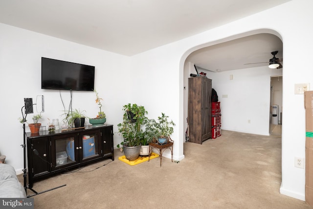 carpeted living room with ceiling fan