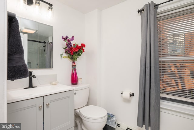 bathroom with tiled shower, vanity, and toilet