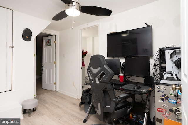 workout area featuring ceiling fan and light hardwood / wood-style flooring