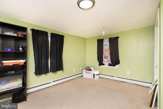 carpeted empty room featuring a baseboard heating unit