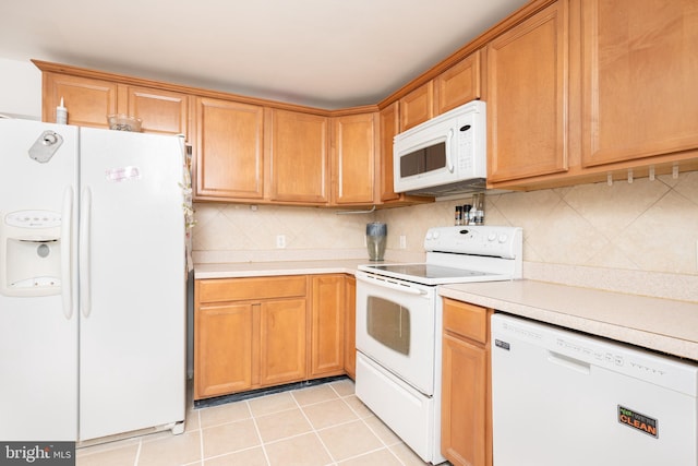 kitchen featuring tasteful backsplash, light tile patterned floors, and white appliances