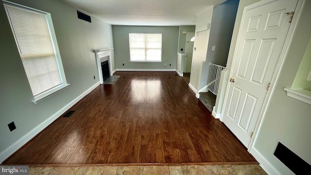 unfurnished living room with dark hardwood / wood-style flooring