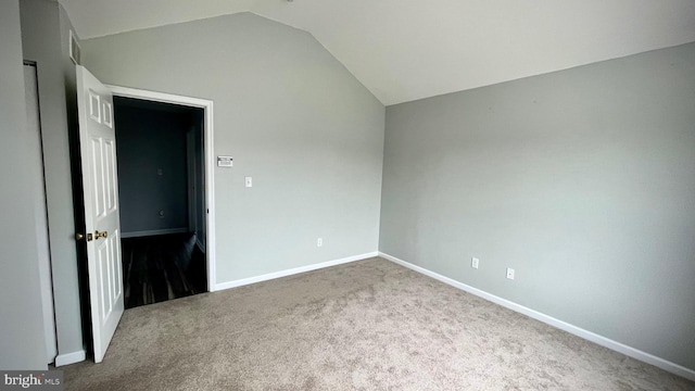 unfurnished room featuring vaulted ceiling and carpet flooring